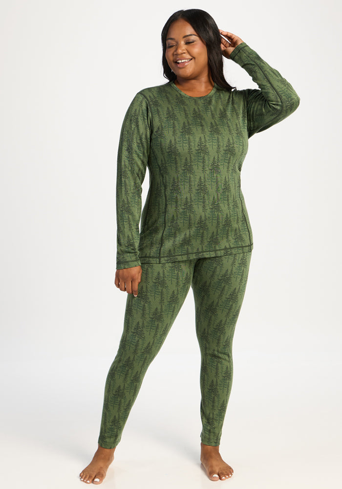 Woman smiles barefoot in Woolx Maddie Baselayer Top - Forest Friends; moisture-wicking comfort and style.