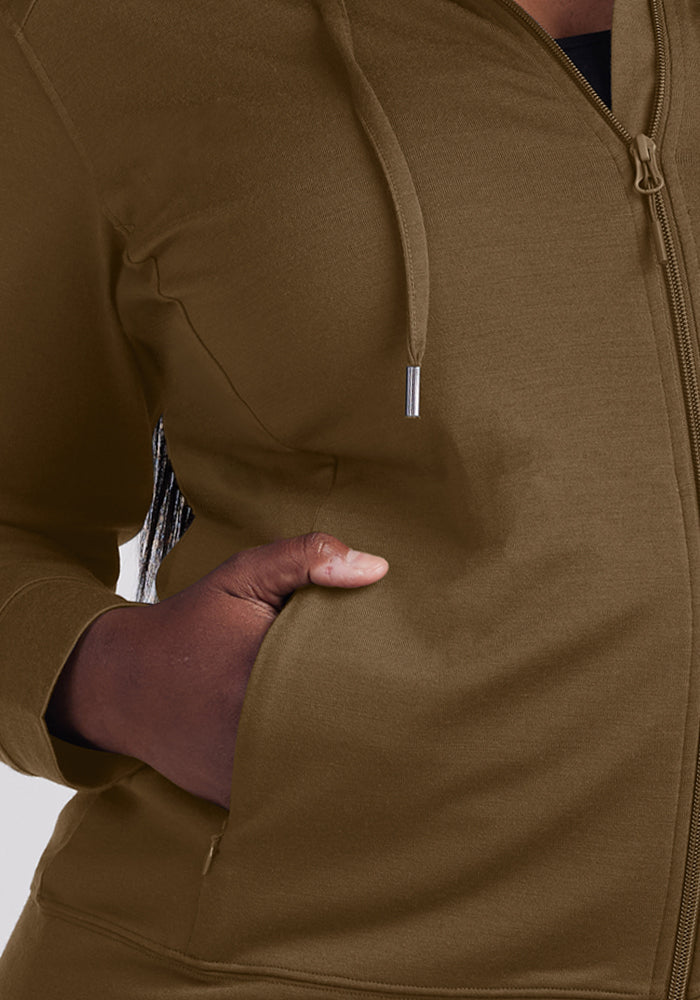 Someone in a Woolx Ryann Hoodie - Olive Leaf slips their left hand into the roomy front pocket, ready for travel.