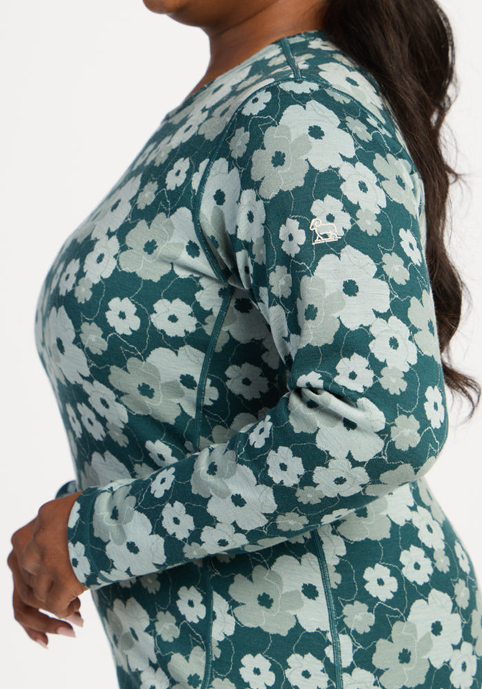 Woman in Woolx Maddie Baselayer Top - Coastal Wildflower, shown side view, hand resting near waist.