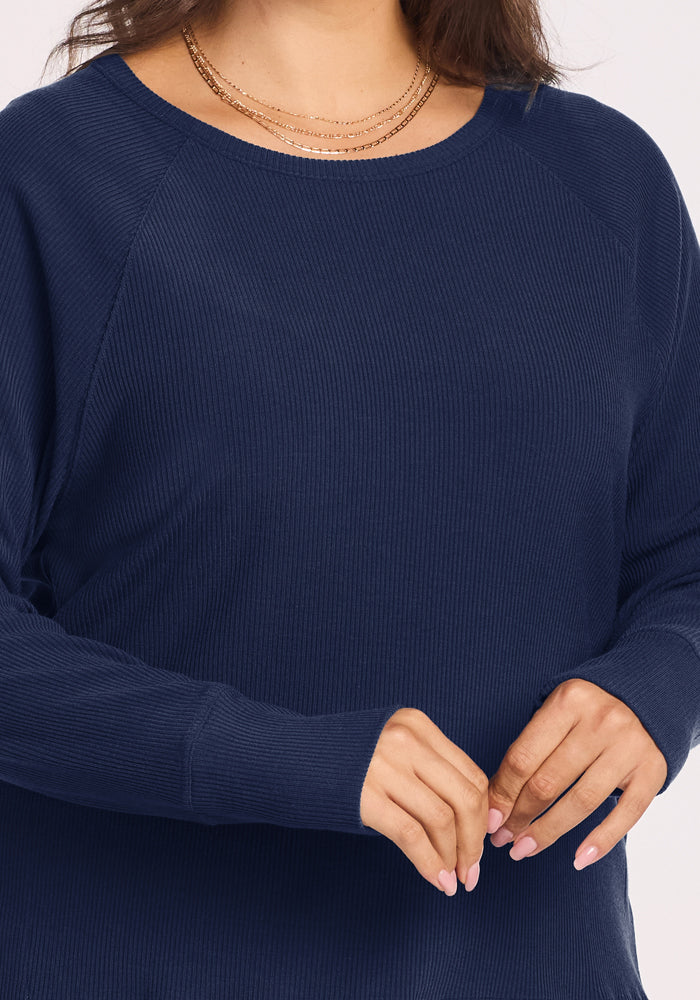 Woman in Woolx Ainsley Sweater - Ocean Cavern, gold layered necklaces, and light pink nails with clasped hands.