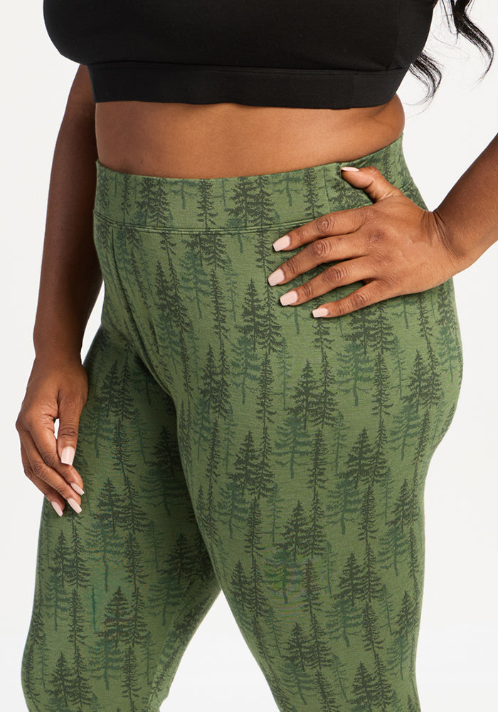 Person wearing Woolx Taylor Baselayer Leggings - Forest Friends and a black crop top, hand on hip.