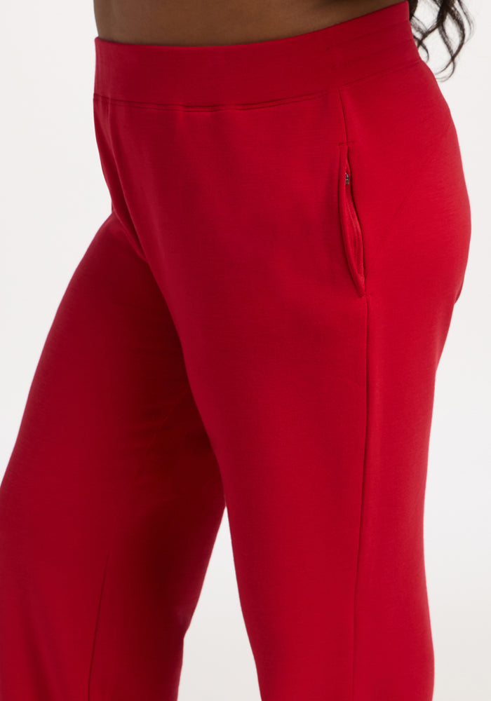 Model wears Woolx Bree Lounge Pants in Maraschino Cherry, featuring a straight leg and side zipper pocket, waist to knee.