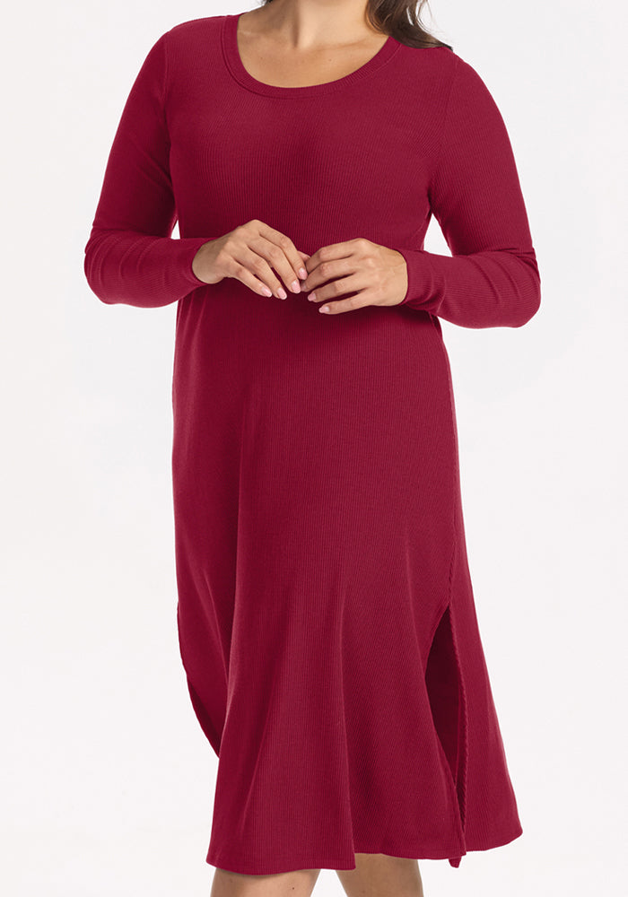 Woman in the Woolx Caroline Ribbed Twirl Dress in Beet Red, long-sleeve with side slits, on white background.