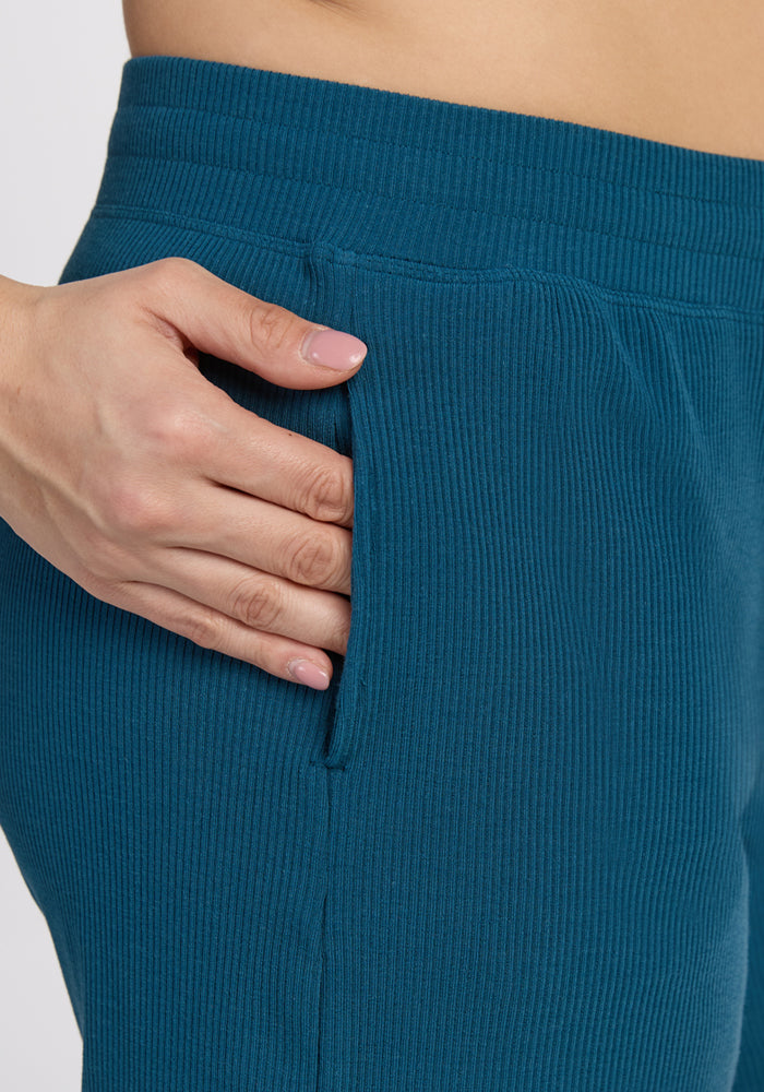 A close-up of a hand in the pocket of Woolx Maisey Ribbed Shorts in Moroccan Blue, highlighting the breathable, moisture-wicking Merino wool fabric and detailed ribbed texture.