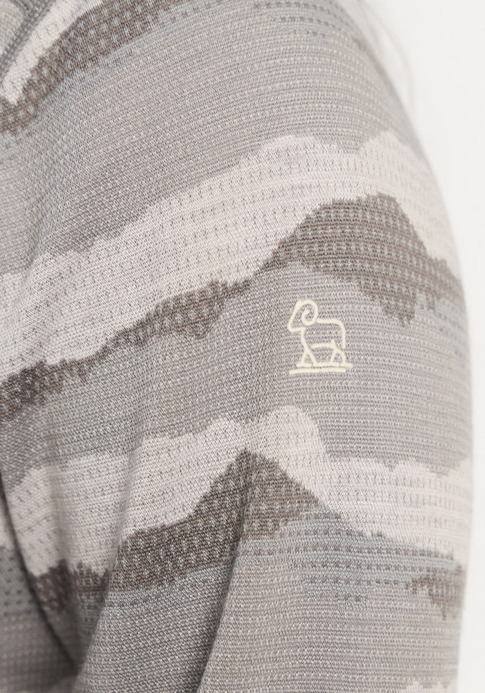 A close-up of textured gray Woolx Emi 1/4 Zip - High Peaks with wavy stripes and a white ram logo on the sleeve.