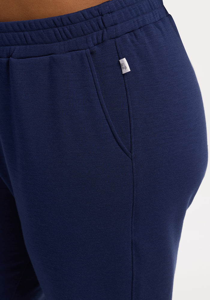 Close-up of a person wearing Woolx Parker Sweatpants - Ocean Cavern, featuring side pocket and elastic waistband.