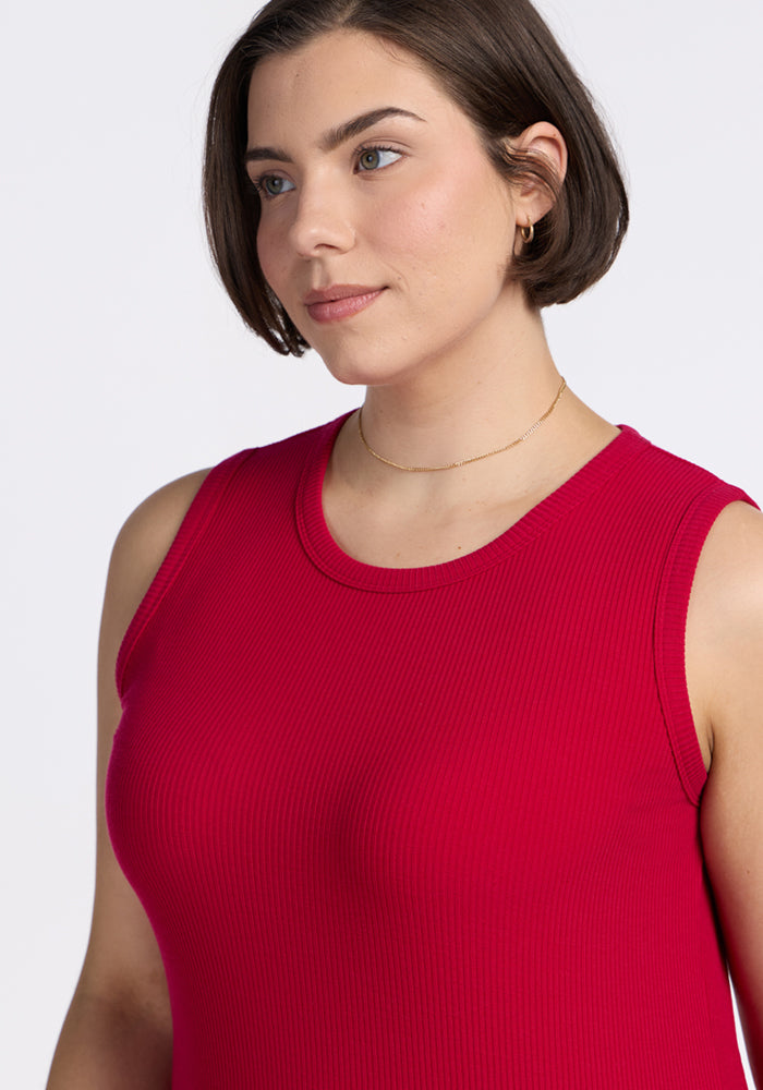 A woman with short brown hair and light skin wears the Woolx Raegan Ribbed Tank Top in Poppy Spark and a thin gold necklace, looking slightly to the side against a plain white background.