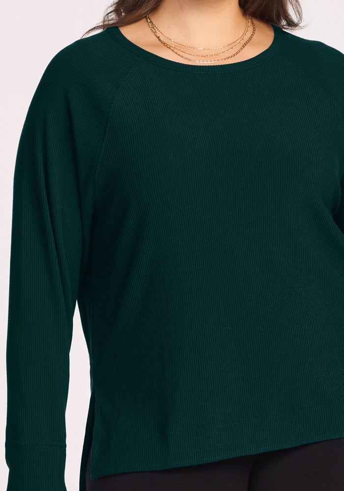 Woman in Woolx Ainsley Sweater – Deep Pine, styled with gold layered necklaces, shown shoulders to hips.