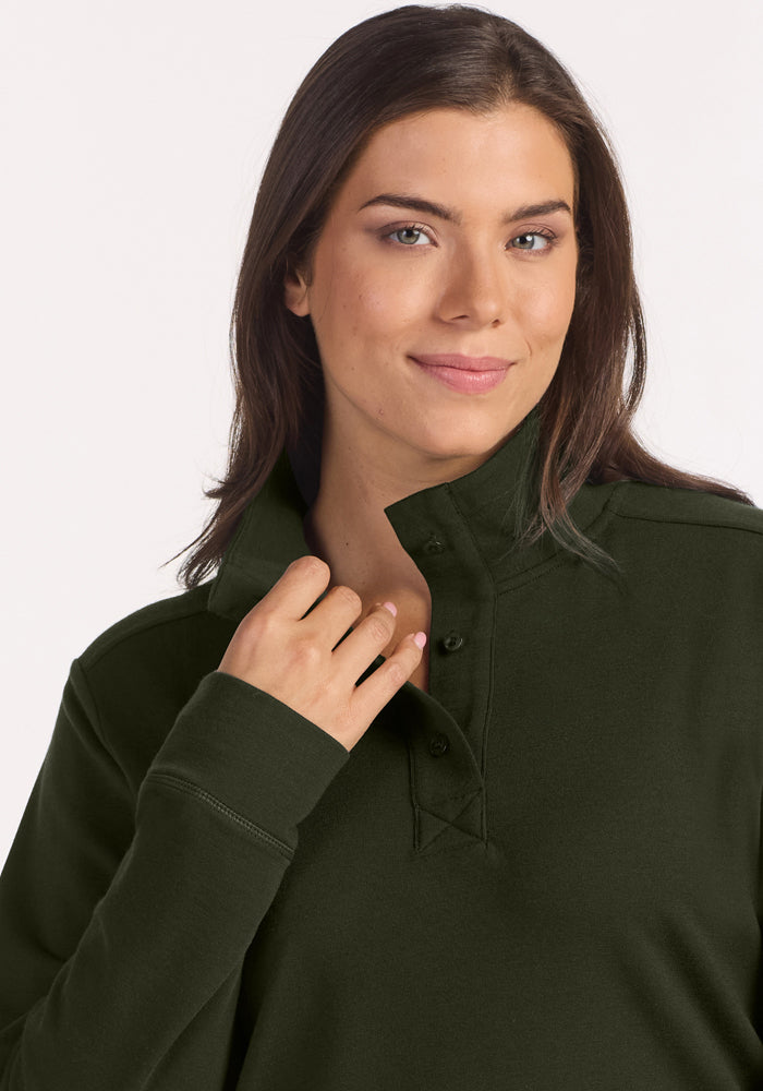 Woman with long brown hair wears Woolx Annie 3 Button Pullover in Duffel Bag, smiling softly at the camera.