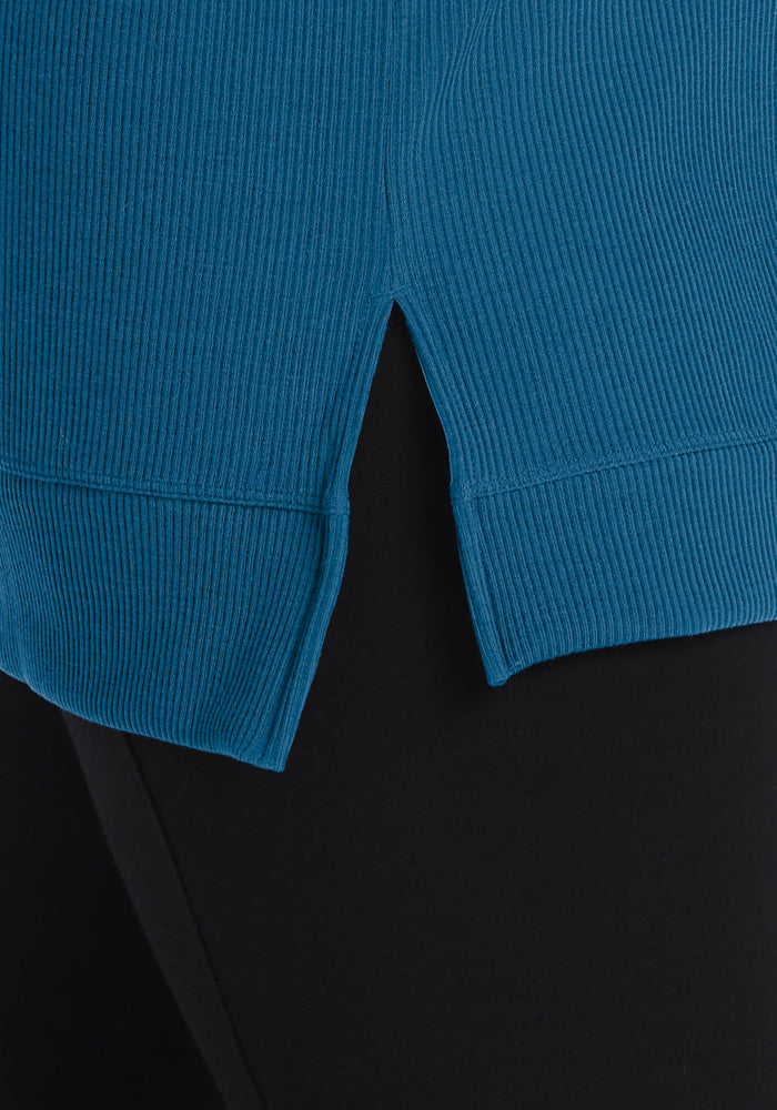 Close-up of the Woolx Evie Petite Tunic in Blue Pine, featuring a side slit, styled with sleek black pants.