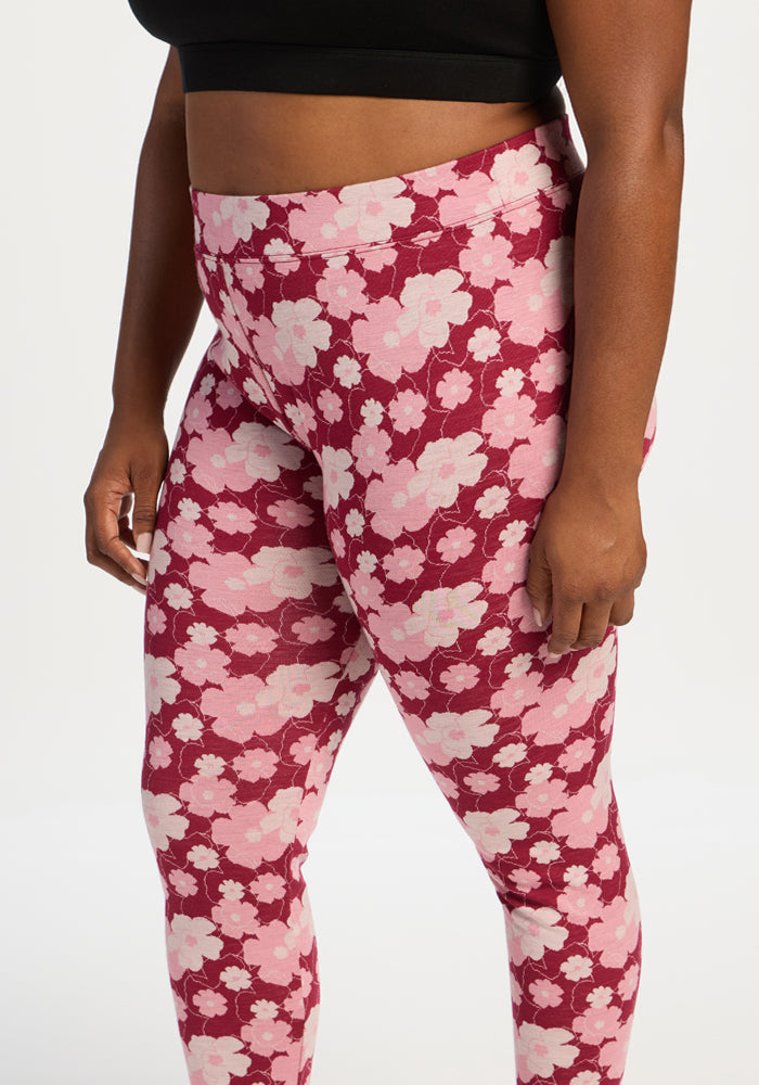 Model in Woolx Taylor Baselayer Leggings - Floral Crush and a black crop top, stands against a plain white background.