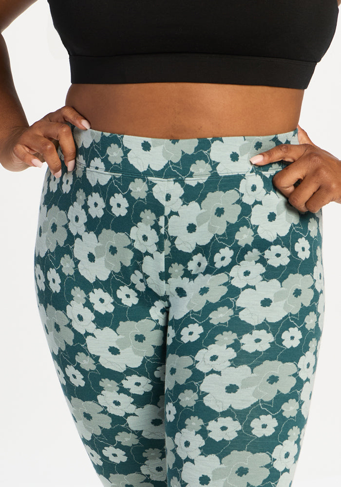Woman in Woolx Taylor Baselayer Leggings - Coastal Wildflower & black crop top, hands on hips, on white background.