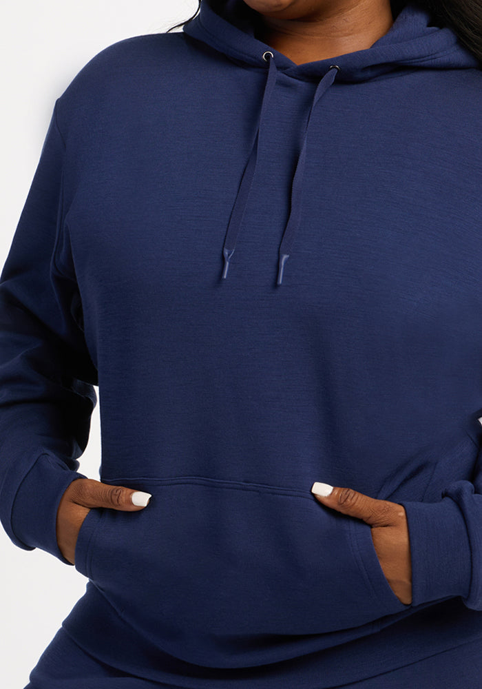 Model in Woolx Avery Hoodie - Ocean Cavern, hands in pocket, face hidden, on white background.