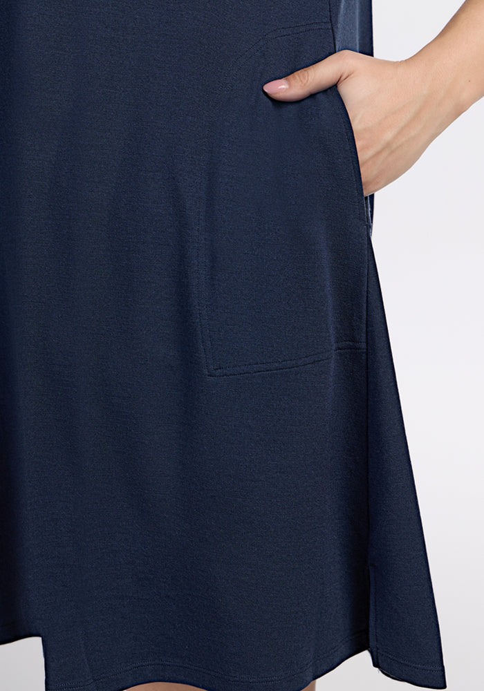 A close-up of a hand in the pocket of the Woolx Rissa A Line Dress in Deep Navy, showcasing Merino wool fabric and pocket detail—ideal for fall and winter layering against a plain background.