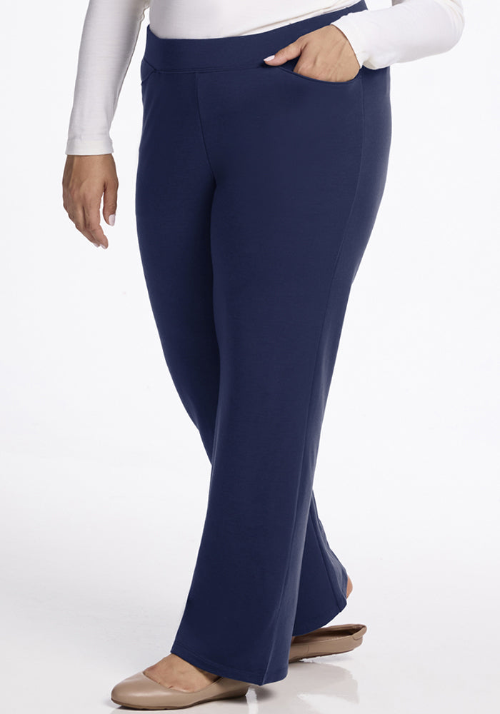 Model in Woolx Ellie Wide Leg Pants - Ocean Cavern, white long-sleeve top, beige flats, hand in pocket.