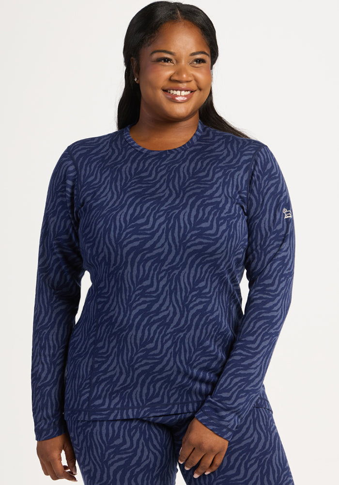 Smiling woman in Woolx Maddie Baselayer Top - Midnight Safari, standing against a white background.