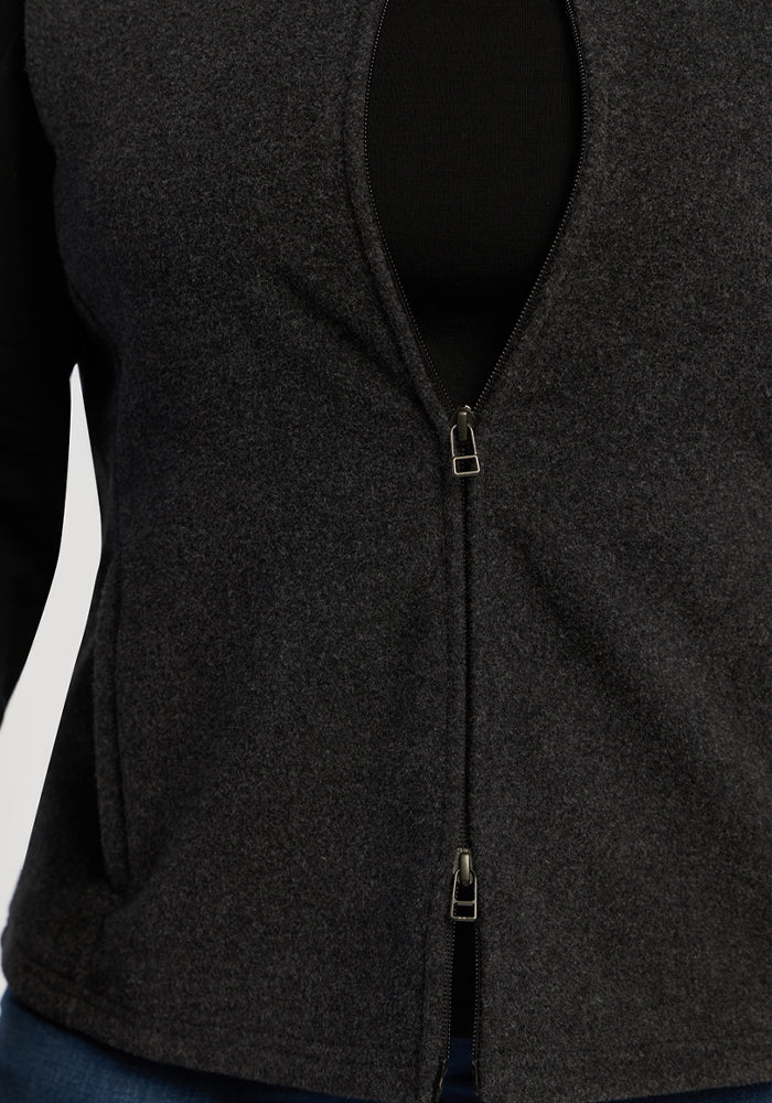 Close-up of the Woolx Haley Vest - Carbon Black, styled over a black top and blue jeans for cozy layering.