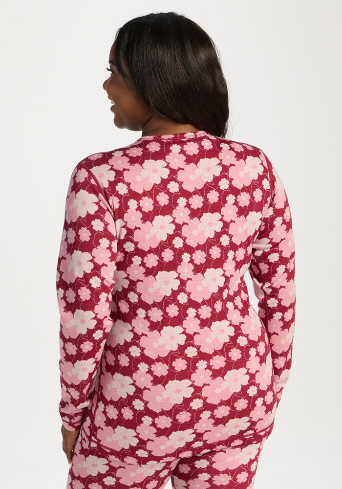 Woman facing away in Woolx Maddie Baselayer Top - Floral Crush, standing against a white background.
