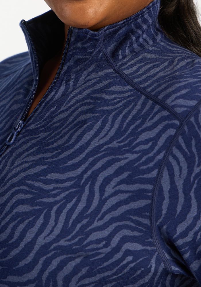 Close-up of a person in the Woolx Emi 1/4 Zip - Midnight Safari, highlighting its temperature regulating collar.