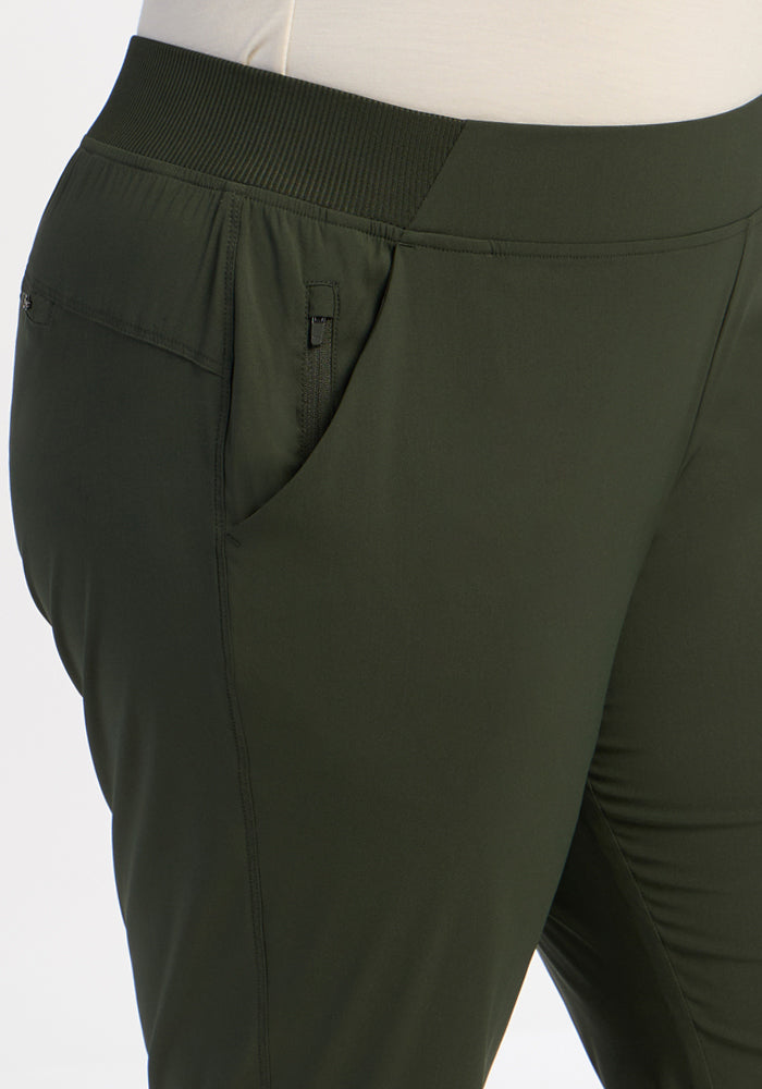 Close-up of a person wearing Woolx Palmer Joggers - Duffel Bag, featuring an elastic waistband and hand in pocket.
