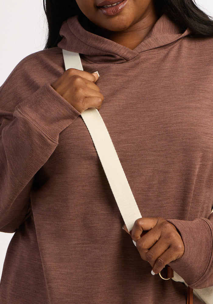 A person wearing a Sable Heather Woolx Genevieve Hoodie and a cream-colored crossbody bag strap.