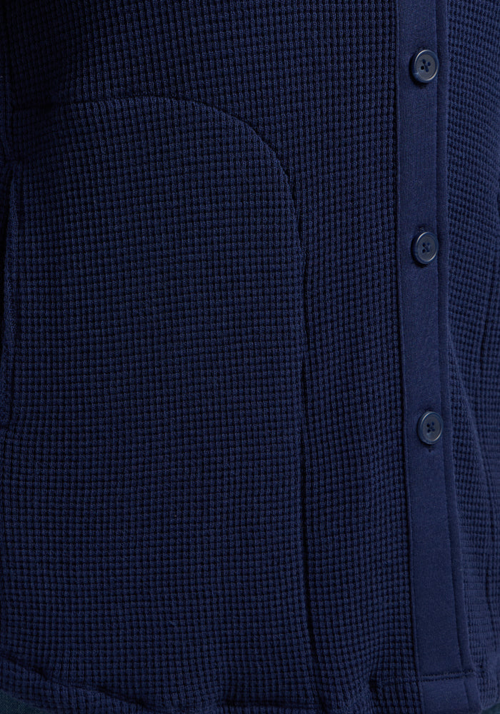 Close-up of the Woolx Oaklynn Waffle Shacket in Ocean Cavern, featuring buttons and a curved side pocket.