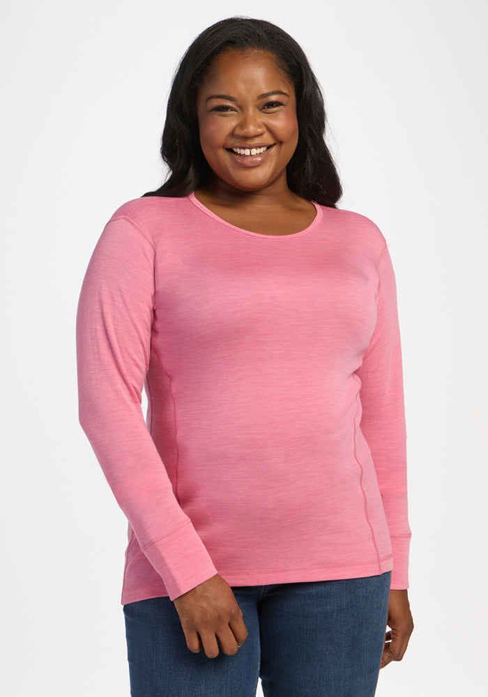 Woman smiling in the Woolx Hannah Long Sleeve Top - Pinky Promise, paired with jeans, against a white background. 