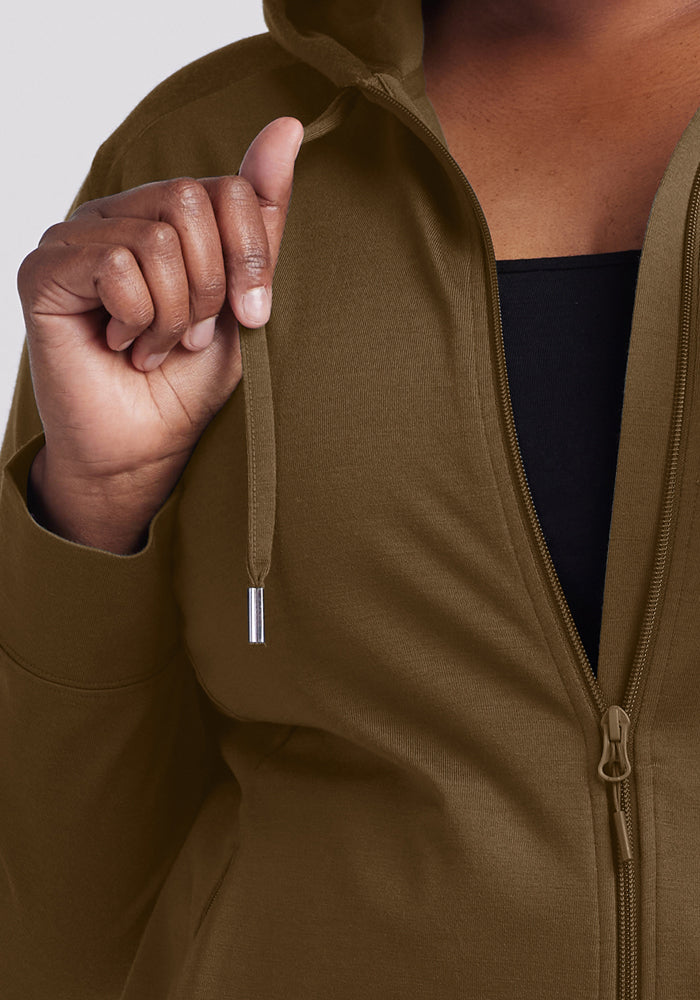 Someone in a Woolx Ryann Hoodie - Olive Leaf holds the string; a black shirt is visible underneath.