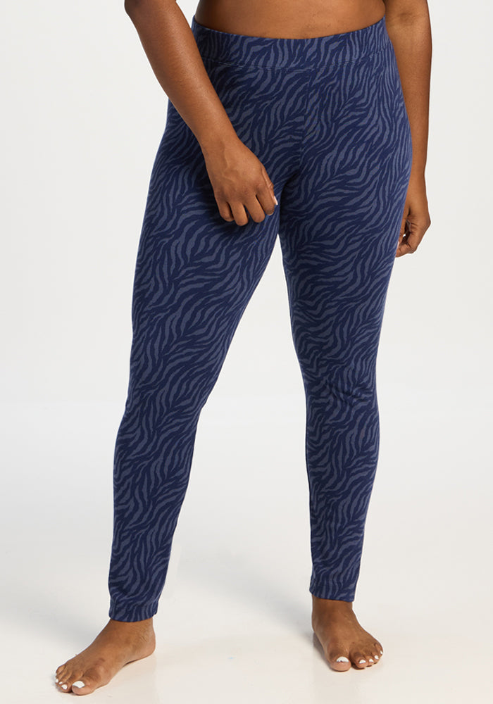 Model in Woolx Taylor Baselayer Leggings - Midnight Safari, standing barefoot against a white background. 