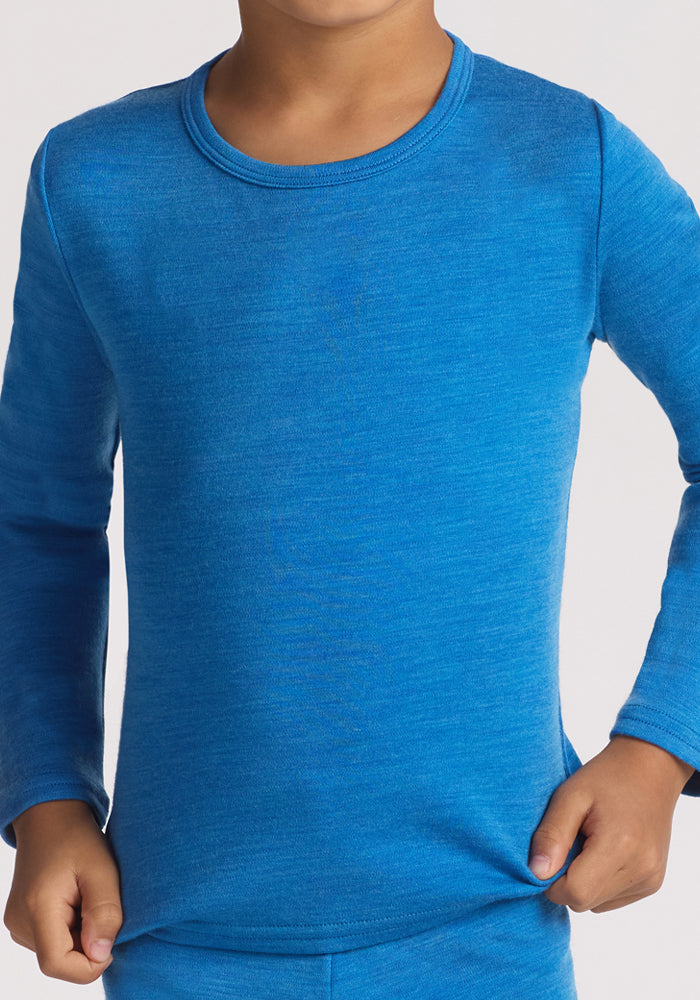 A child, face not shown, holds the hem of a vibrant blue Woolx Kids Explorer Base Layer Top - Blue Razz, made from soft Australian Merino wool with full arm coverage.