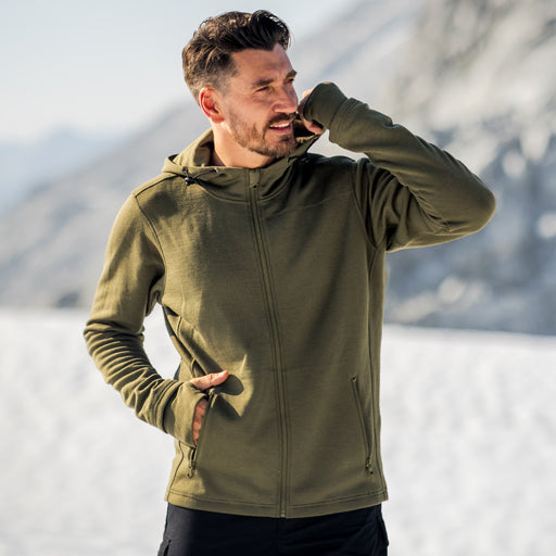 Man wearing a green jacket in a snowy landscape