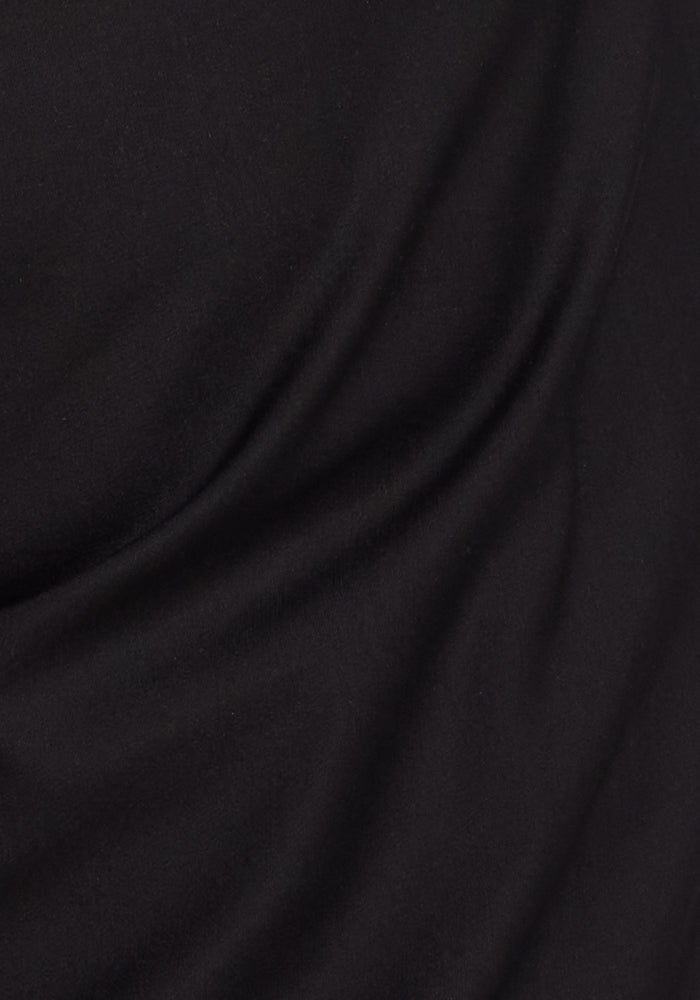Close-up of black Woolx Cooper Windbreaker fabric with visible folds and soft diagonal creases.