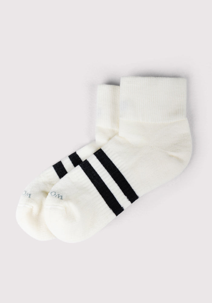 The Woolx Womens Rambler Ankle Sock in Polar White features two black stripes near the top for style and is designed for optimal moisture management, shown against a light gray background.