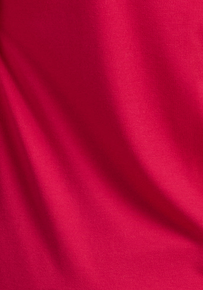 Close-up of smooth red fabric with soft folds and shadows, highlighting the cozy texture and depth of the Woolx Rissa A Line Dress in Poppy Spark—ideal for fall/winter or as a versatile travel dress.