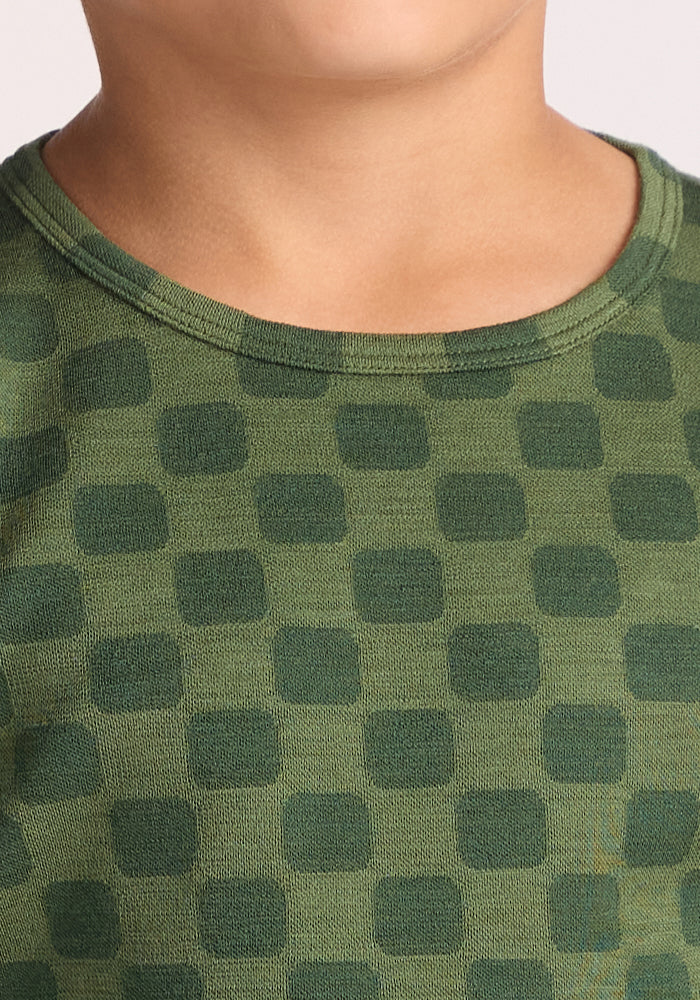 Close-up of a child wearing the Woolx Kids Explorer Base Layer Top - Frog Hop, featuring a green square pattern. Only the lower half of their face, neck, and upper chest are visible.