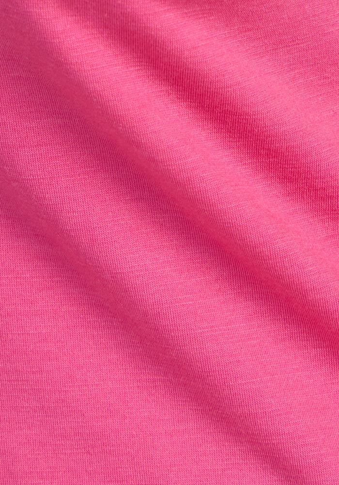 Close-up of the Woolx Jenny 3/4 Sleeve Crew Neck in Raspberry Fizz, showing its fine DuraLite Merino wool texture, visible weave patterns, and lightweight design under a diagonal shadow.