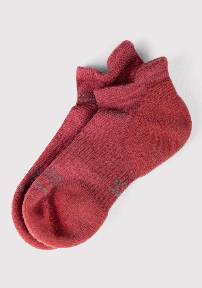 A pair of Woolx Womens Rowan No Show Socks in Rhubarb, featuring a slightly darker heel, toe, and cuff, neatly stacked on a light gray background.