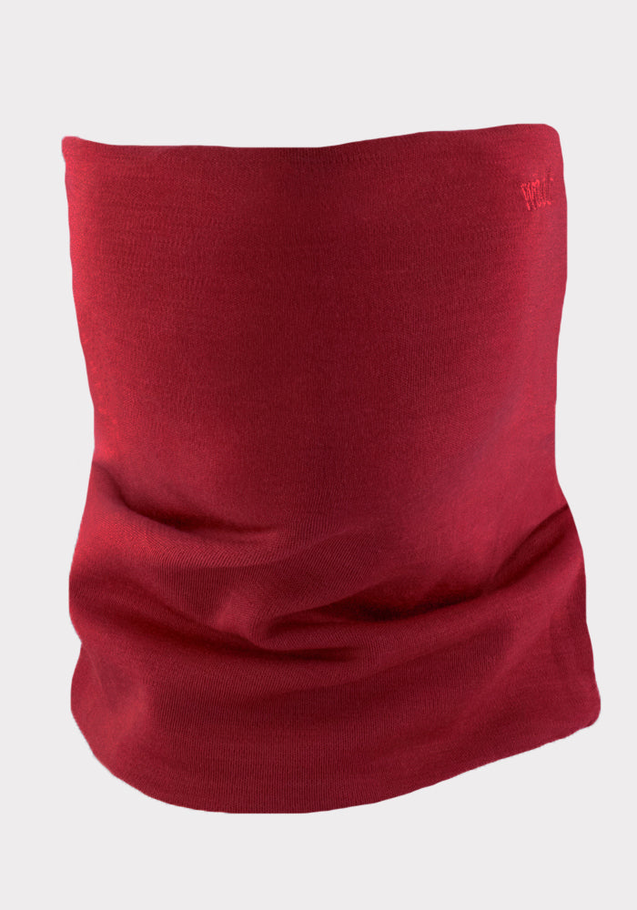 The Woolx Neck Gaiter - Rhubarb, crafted from soft, stretchy Merino wool, is displayed upright with subtle folds against a light gray background. The seamless red design highlights its comfortable fit and quality fabric.