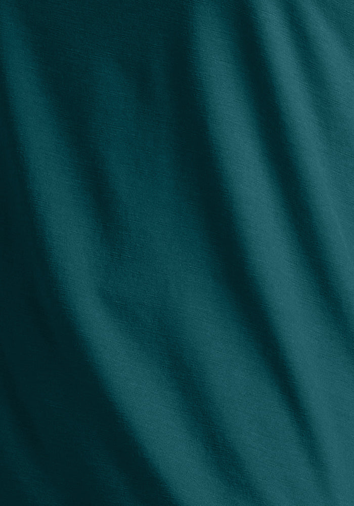 Close-up of the Woolx Essential Tee in Riverbank Green, showcasing its lightweight merino wool fabric with gentle folds and subtle texture—ideal for athletic tees or performance long sleeves.