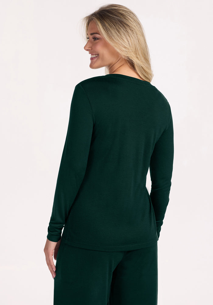 A woman viewed from behind wearing a deep pine Woolx Lily V Neck Lounge Top made of Merino wool.