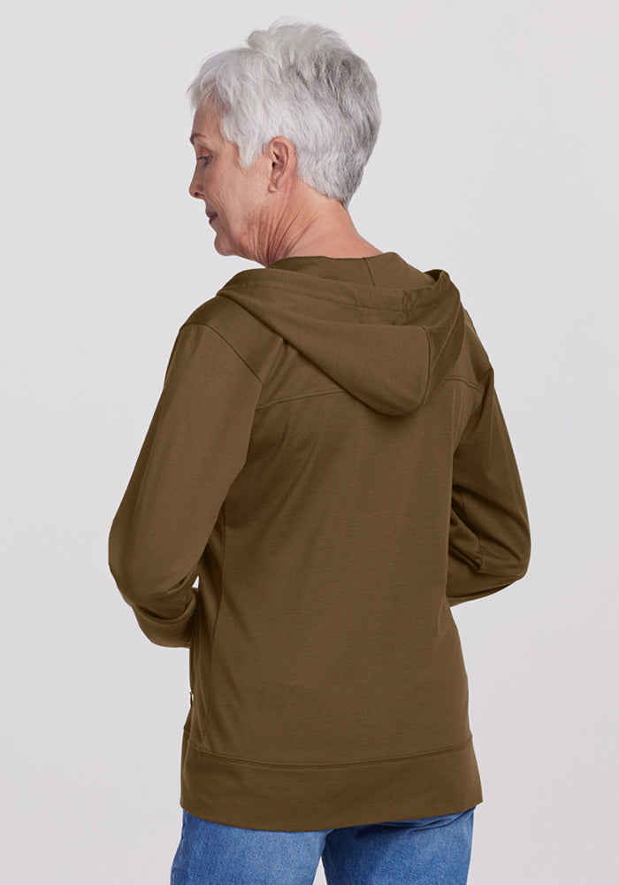 Older woman with short gray hair in a Woolx Ryann Hoodie - Olive Leaf and blue jeans, facing away from camera.