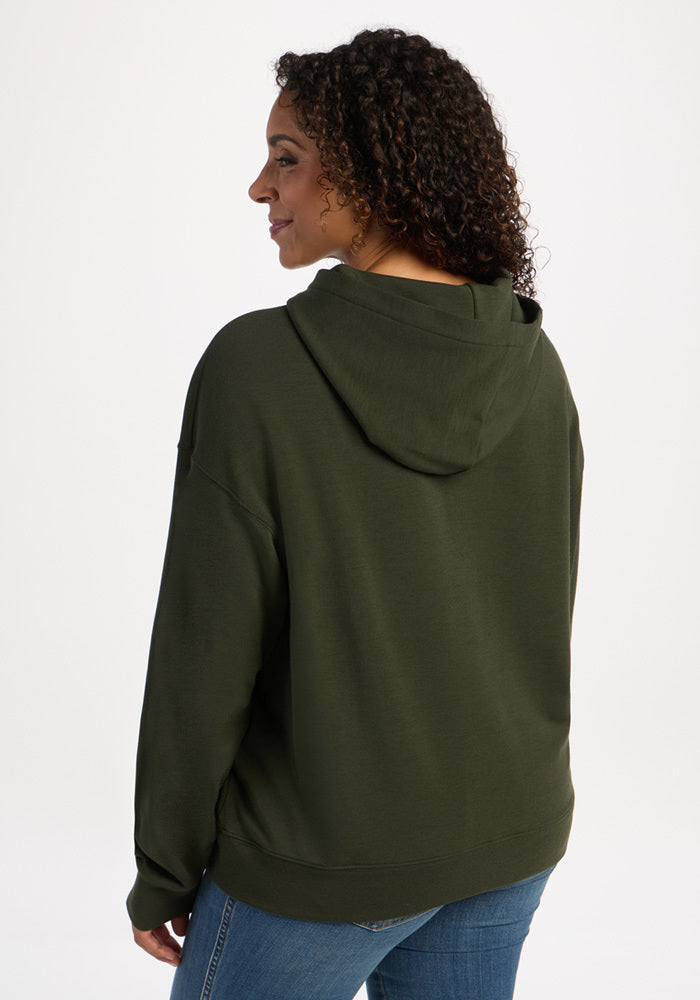 Woman wearing a dark olive green merino wool long-sleeve Genevieve Hoodie - Duffel Bag.