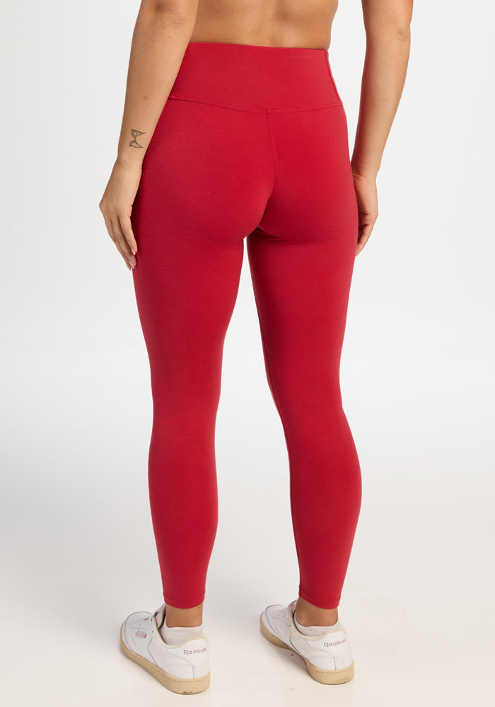 A person seen from behind wearing comfortable high-waisted Woolx Angela Leggings - Maraschino Cherry and white sneakers.