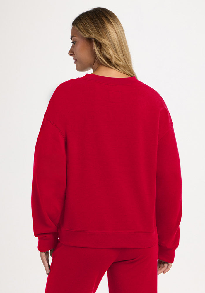 A person seen from behind wearing a moisture-wicking, bright red Molly Crewneck - Maraschino Cherry and matching pants.