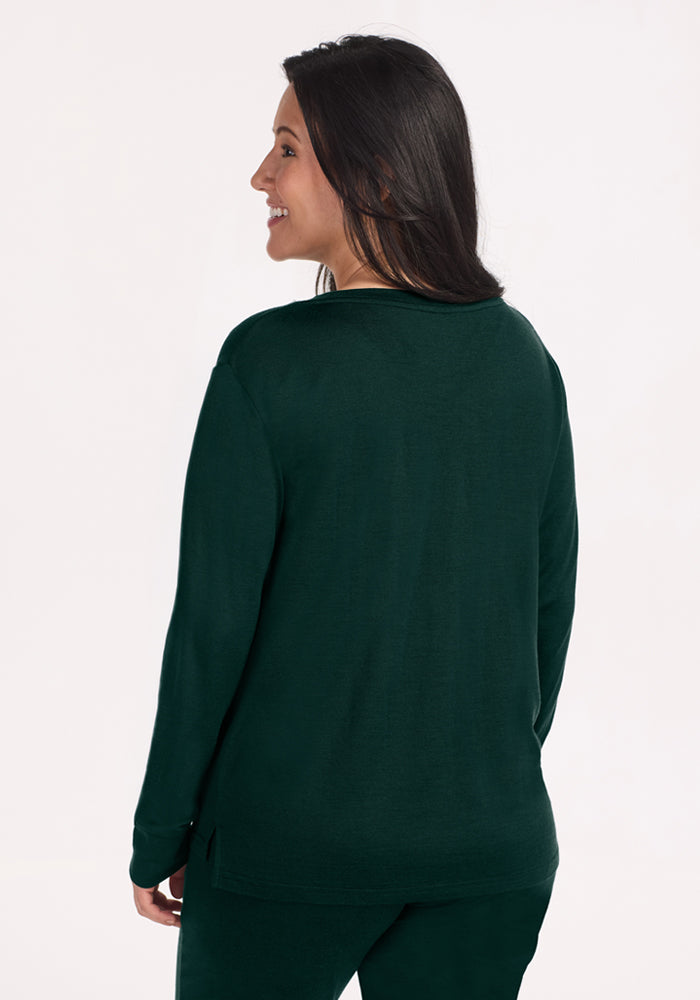 A woman seen from the back wearing a long-sleeved, wrinkle-resistant dark green Ashlie Lounge Top in Deep Pine.