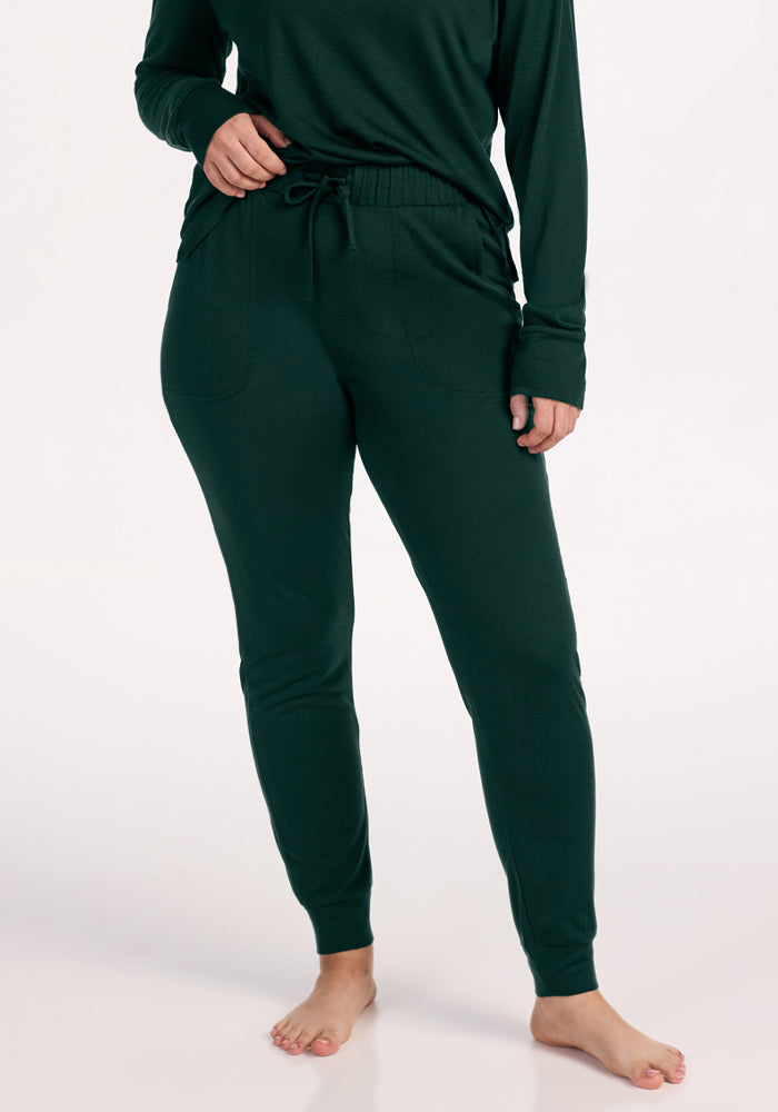 Deep Pine Woolx Mary Kate Lounge Pants in dark green merino wool with an elastic drawstring waist, pockets, and cuffed hems. | Sarah is 5'8", wearing a size S