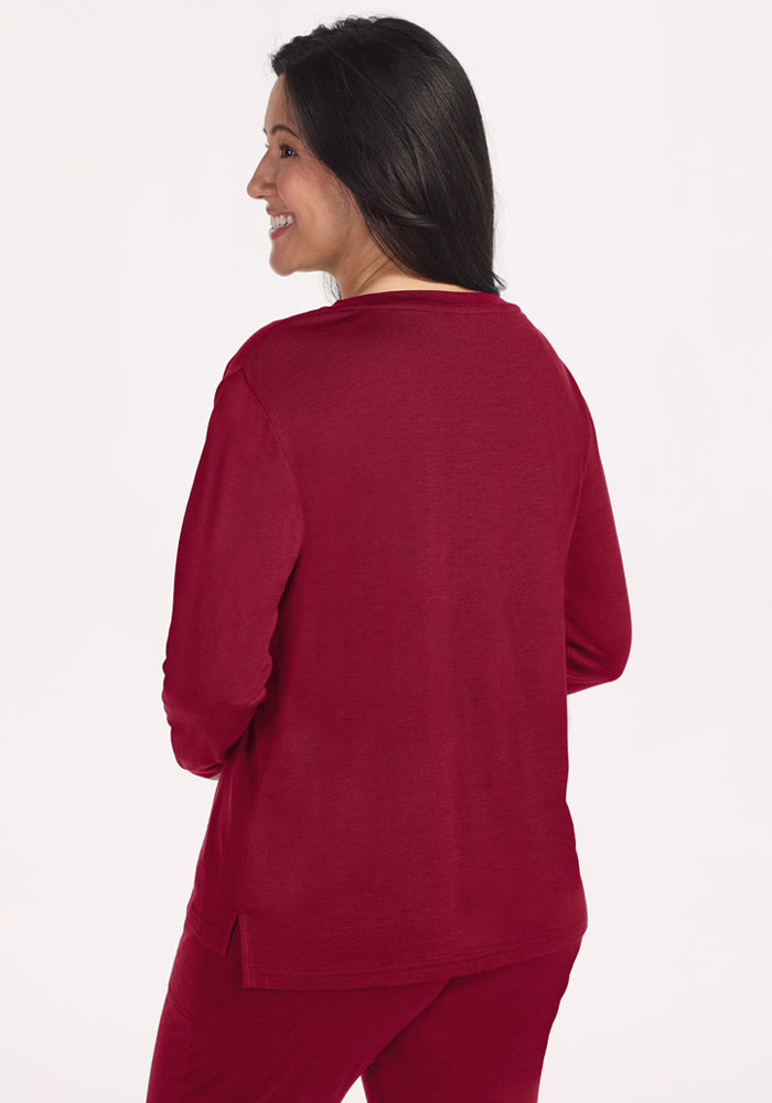 Back view of a woman wearing a beet red Ashlie Lounge Top with side slits.