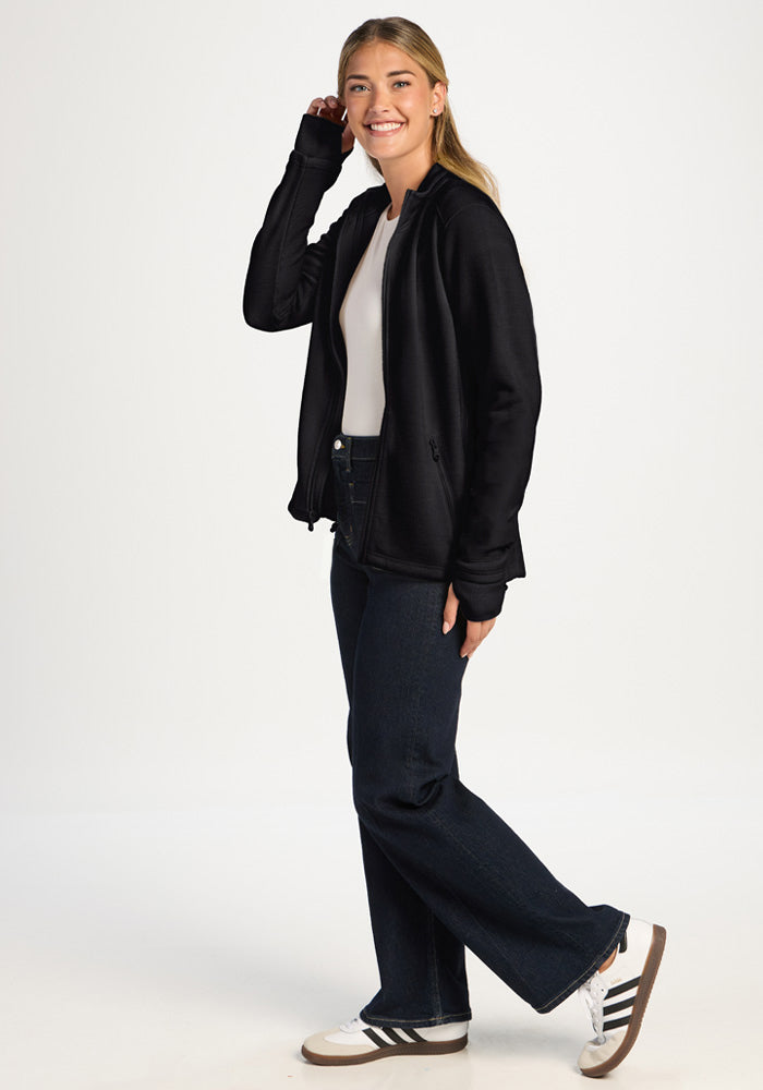 Woman wearing a black Woolx Teddy Sweatshirt over a white top and dark jeans.