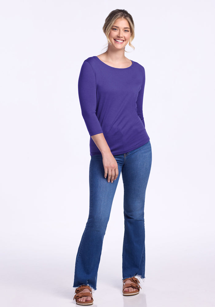 Smiling woman in Woolx Jenny 3/4 Sleeve Crew Neck - Berry Indigo and blue jeans, against a white background.