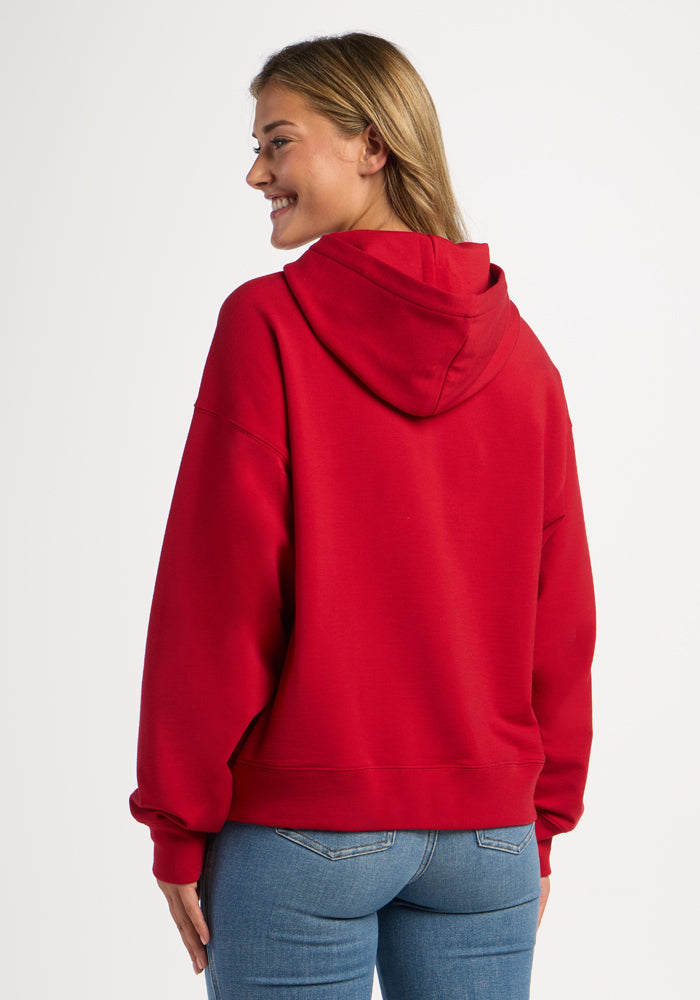 Back view of a person in a Maraschino Cherry Woolx Genevieve Hoodie and blue jeans.